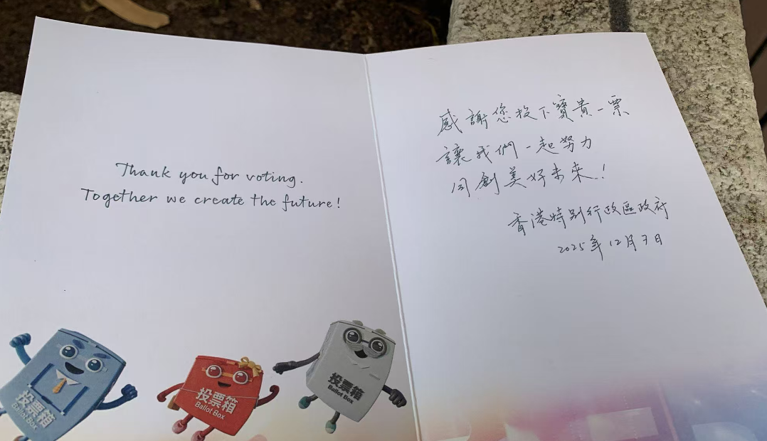 選民持心意卡在票站外拍照留念 冀選出議員為民服務(wù)