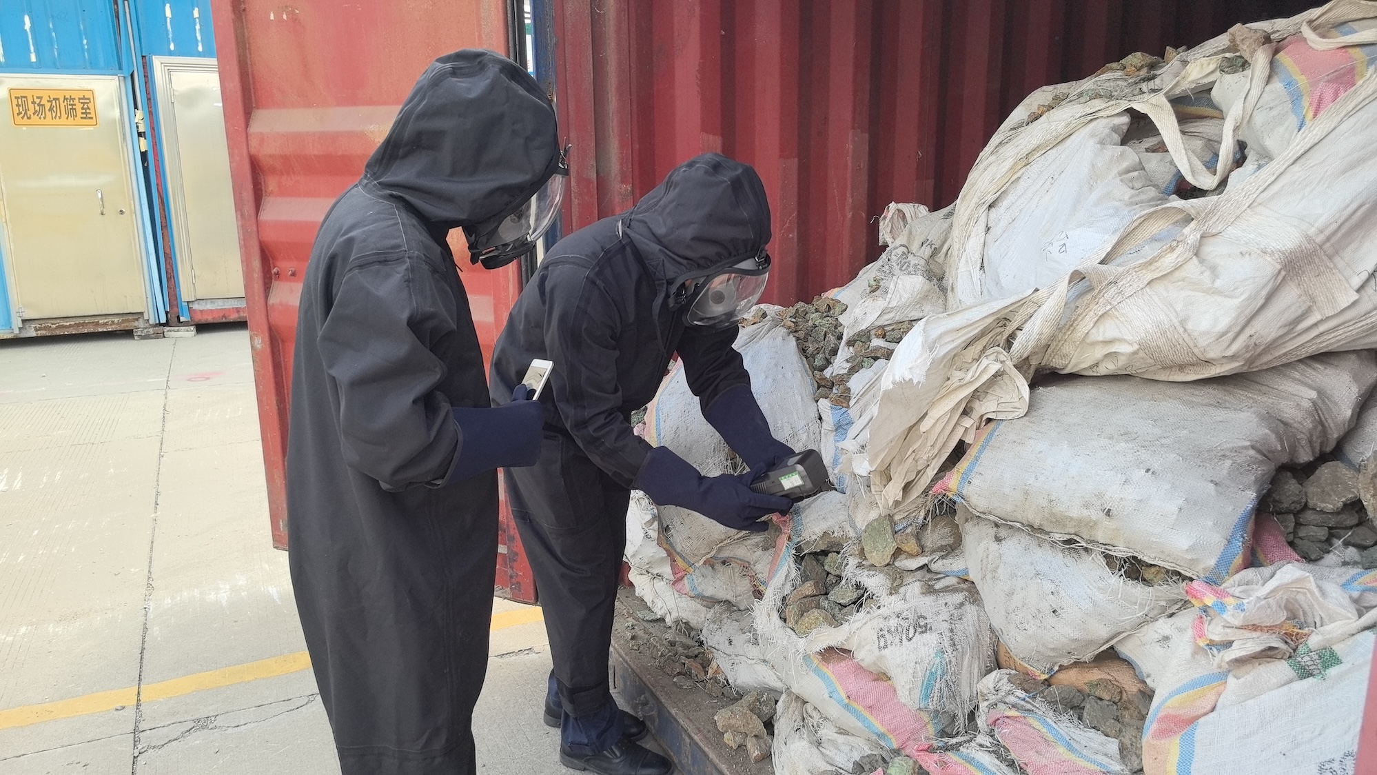 廣州海關(guān)所屬花都海關(guān)關(guān)員對(duì)放射性超標(biāo)進(jìn)口銅礦砂進(jìn)行查驗(yàn).jpg