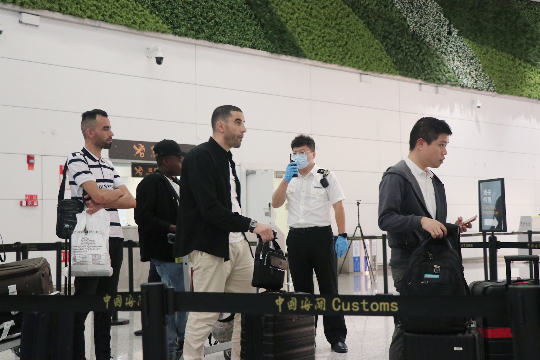 圖為：廣州白雲(yún)機(jī)場(chǎng)海關(guān)關(guān)員對(duì)進(jìn)境旅客進(jìn)行監(jiān)管（關(guān)蕓 攝）.jpg